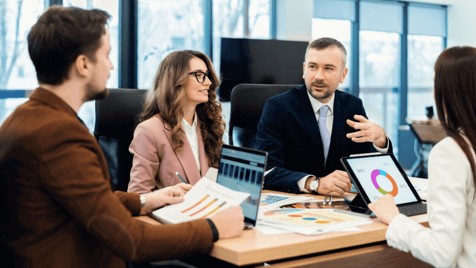 4 gerentes reunidos en una oficina revisando cómo funciona el feedback 360 grados
