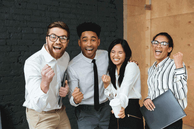 4 colaboradores de una compañía en exterior, sonriendo y celebrando los resultados en la retroalimentación de 360 grados